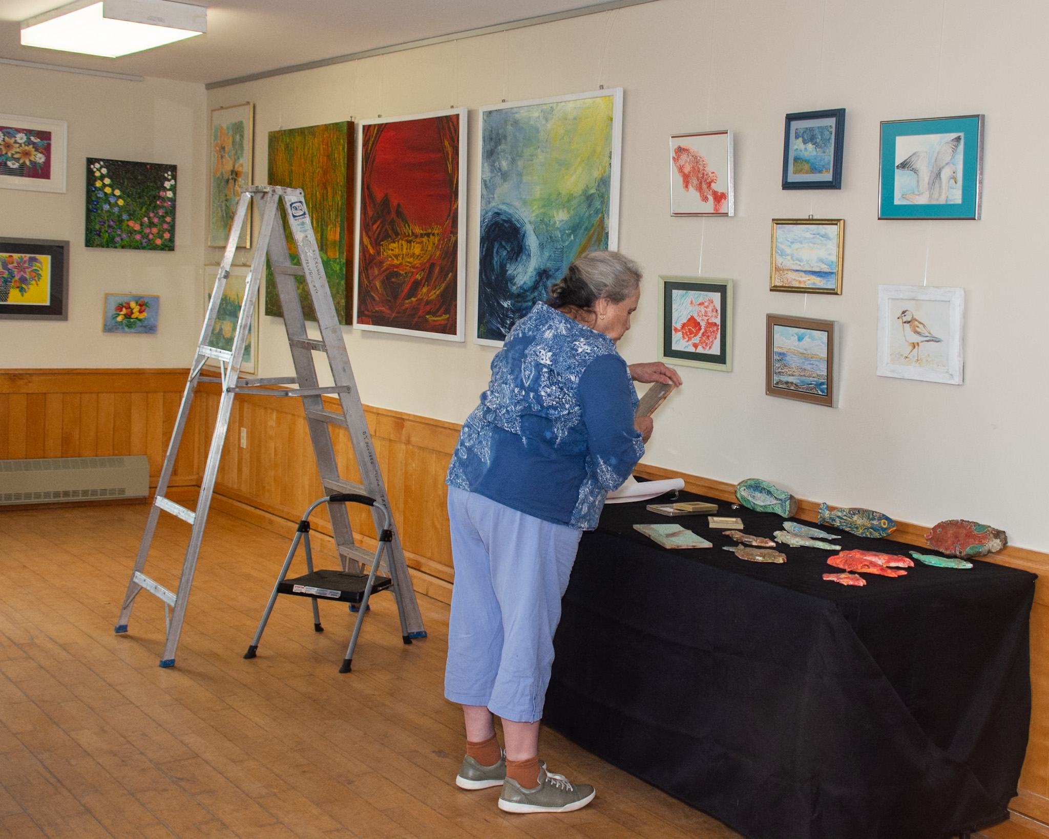 woman working on art displays in an art gallery