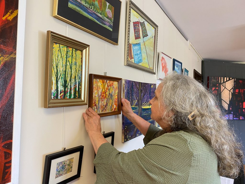 woman hanging pictures